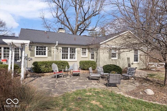 back of property with a chimney and a patio area