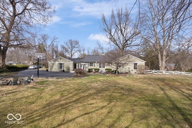 exterior space featuring aphalt driveway, a front yard, and fence