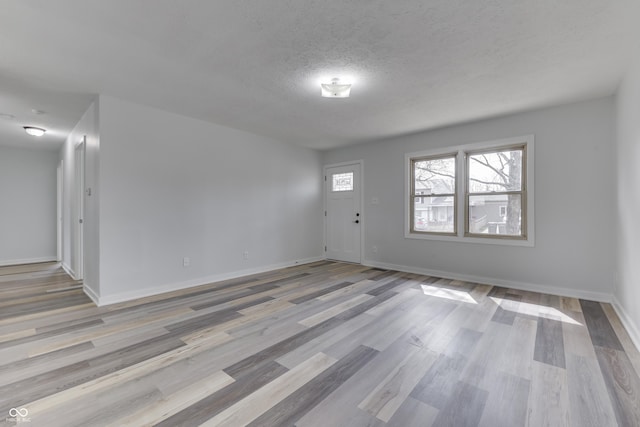 entrance foyer with wood finished floors, baseboards, and a textured ceiling