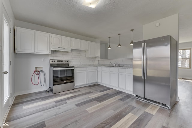 kitchen with a sink, stainless steel appliances, white cabinets, under cabinet range hood, and backsplash