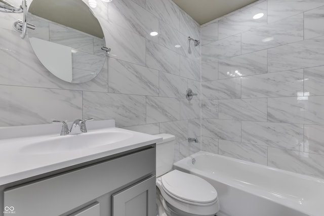 bathroom featuring toilet, tub / shower combination, vanity, and tile walls