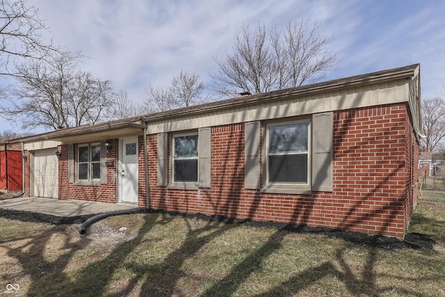 ranch-style house featuring brick siding, a front yard, and a garage