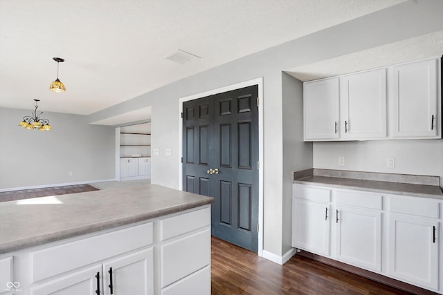 kitchen with a chandelier, visible vents, dark wood finished floors, and white cabinetry