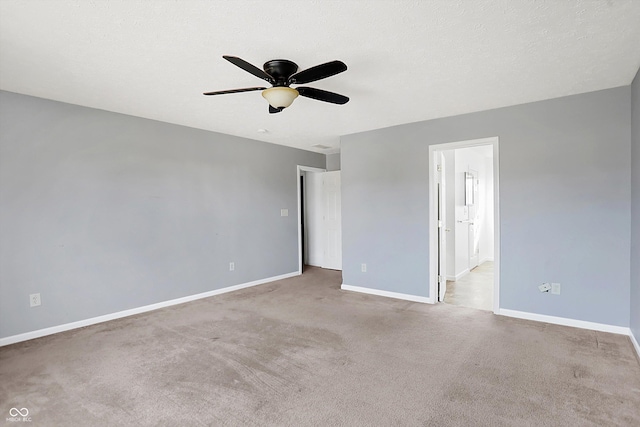 empty room featuring a ceiling fan, baseboards, carpet floors, and a textured ceiling