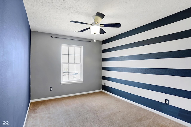 carpeted empty room featuring baseboards, a textured ceiling, and a ceiling fan