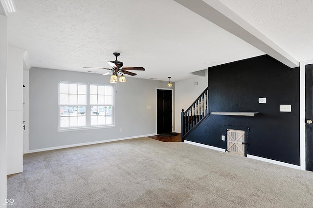 unfurnished living room with baseboards, stairs, carpet flooring, a textured ceiling, and a ceiling fan