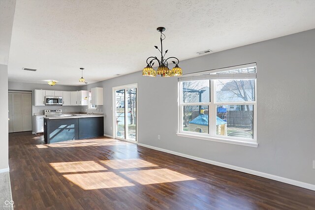 interior space featuring a chandelier, visible vents, and a textured ceiling