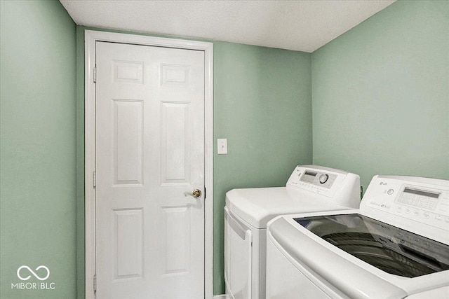 laundry room with a textured ceiling, independent washer and dryer, and laundry area