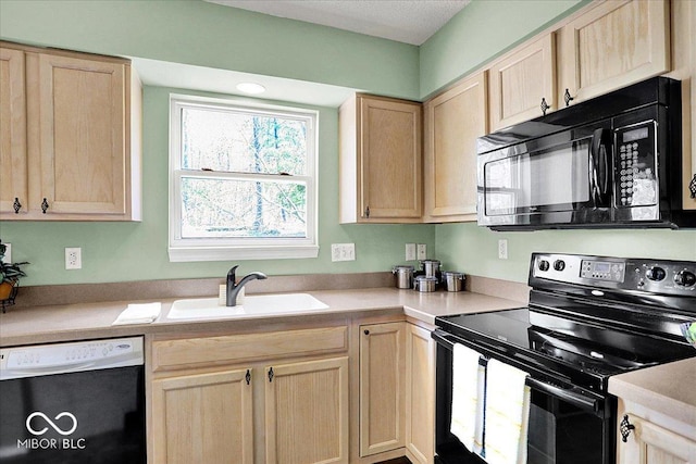 kitchen featuring a sink, black appliances, light countertops, and light brown cabinetry