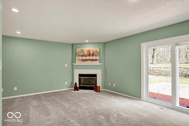 unfurnished living room featuring carpet flooring, a fireplace, visible vents, and baseboards