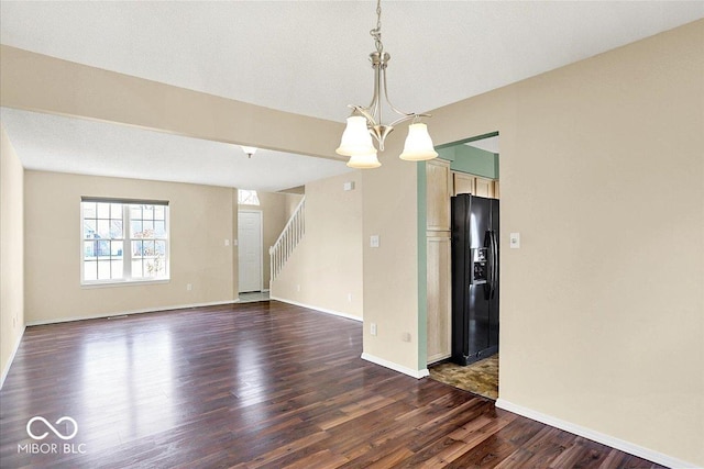 unfurnished room featuring a chandelier, stairs, dark wood-type flooring, and baseboards