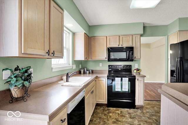 kitchen with black appliances, light countertops, light brown cabinetry, and a sink