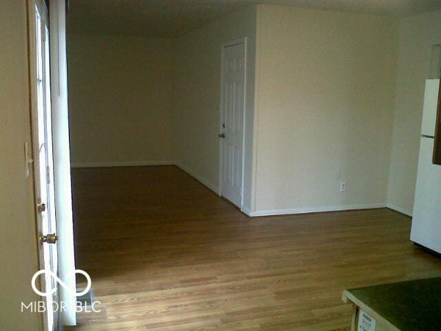 unfurnished room featuring baseboards and light wood-type flooring