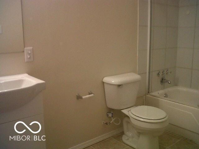 bathroom with toilet, vanity, tile patterned flooring, baseboards, and shower / bathtub combination