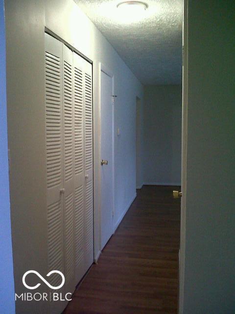 hallway featuring a textured ceiling and wood finished floors