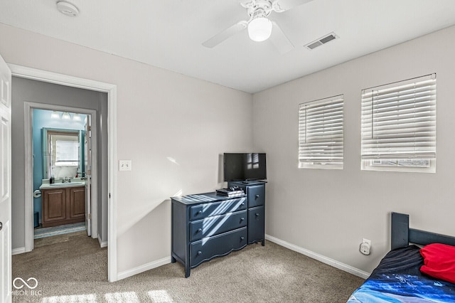 bedroom featuring visible vents, baseboards, light carpet, a ceiling fan, and a sink