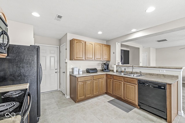 kitchen featuring black appliances, light countertops, visible vents, and a sink