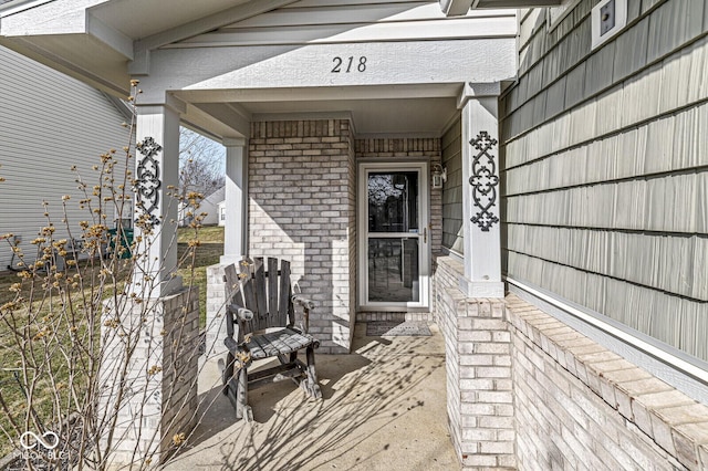 doorway to property featuring brick siding