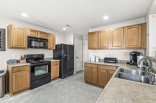 kitchen featuring visible vents, black appliances, a sink, recessed lighting, and light countertops