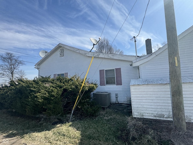 view of home's exterior with cooling unit and a chimney