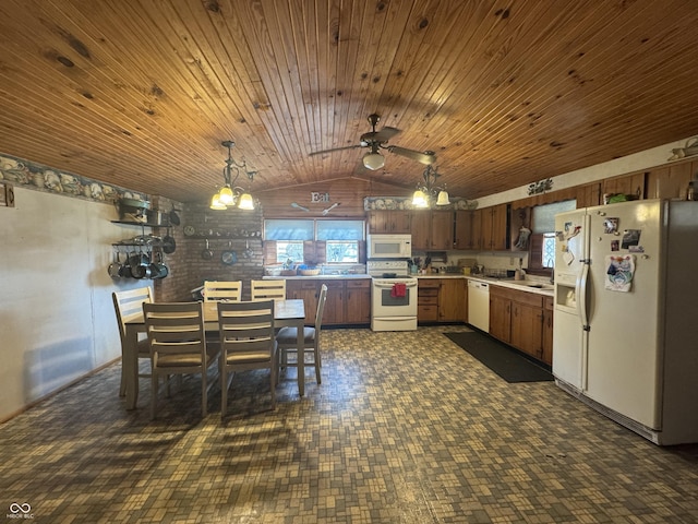 kitchen featuring white appliances, lofted ceiling, a sink, hanging light fixtures, and light countertops