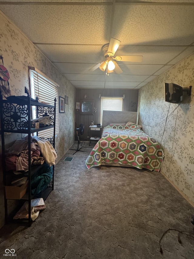 unfurnished bedroom featuring visible vents, carpet floors, a ceiling fan, and wallpapered walls