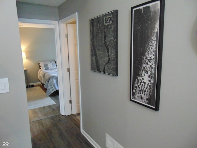 corridor with baseboards and dark wood-type flooring