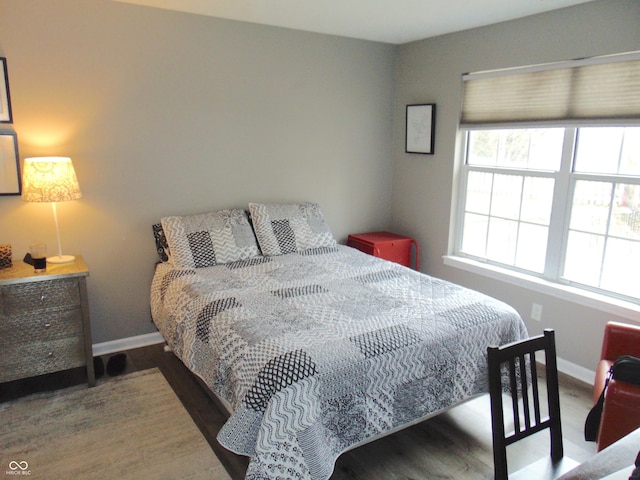 bedroom with baseboards and wood finished floors