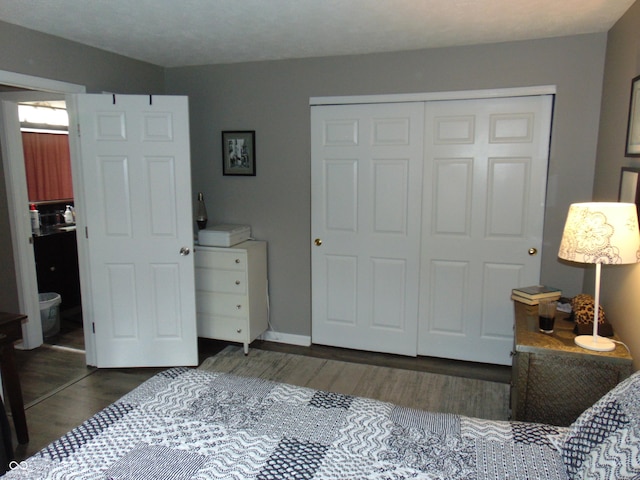 bedroom featuring wood finished floors, a closet, and baseboards