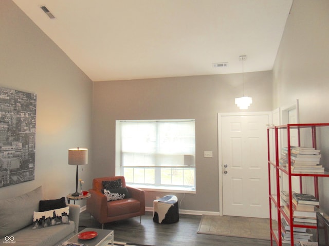 living room featuring wood finished floors, visible vents, and baseboards