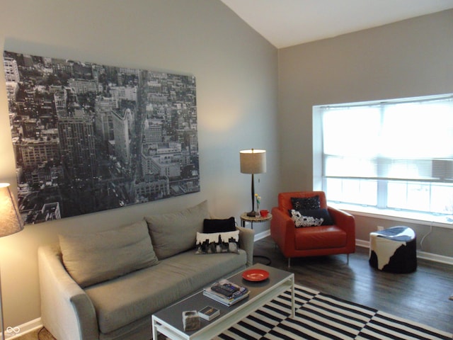 living area with vaulted ceiling, wood finished floors, and baseboards