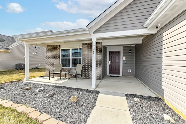 entrance to property featuring brick siding and covered porch