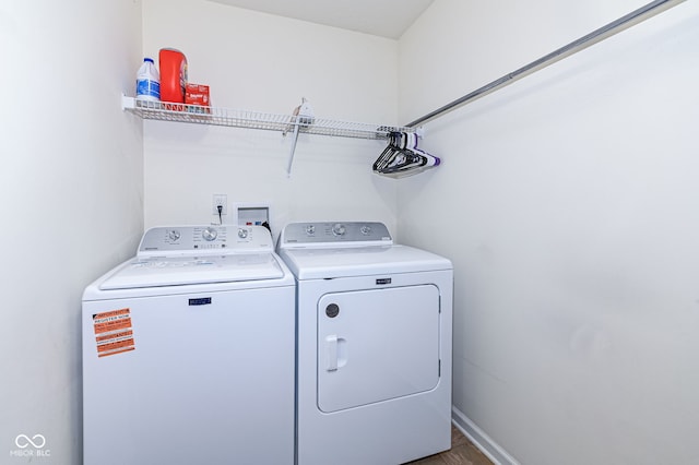 washroom featuring laundry area, washer and dryer, and baseboards