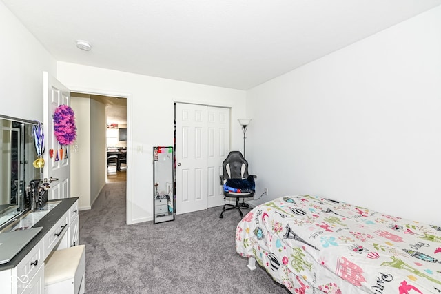 carpeted bedroom featuring a closet and baseboards