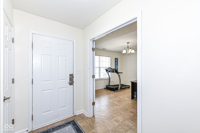 entrance foyer with a chandelier and baseboards