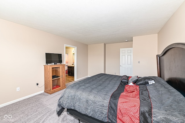 bedroom featuring carpet flooring, connected bathroom, a textured ceiling, and baseboards