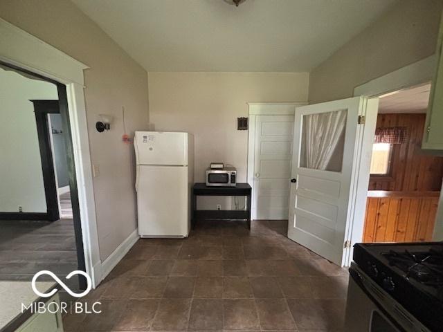 1713 Charles St, Lafayette, IN 47904 - kitchen with freestanding refrigerator, stainless steel microwave, baseboards, and range with gas stovetop