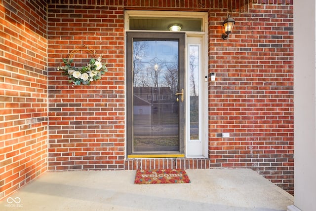 doorway to property with brick siding