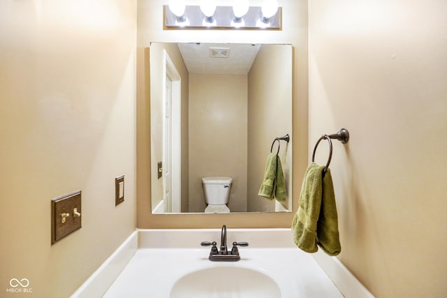 bathroom featuring toilet and vanity