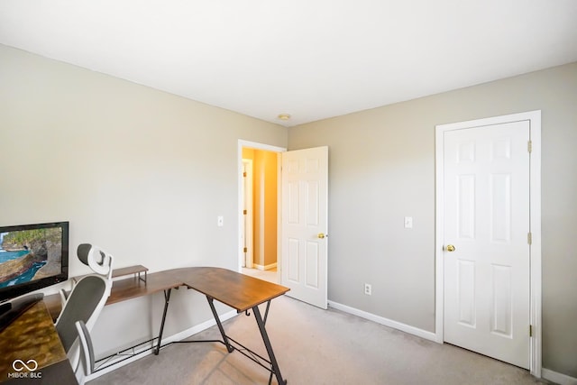 home office with baseboards and light carpet