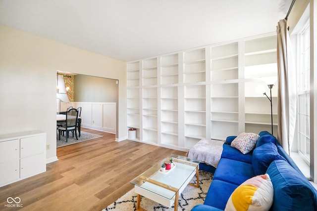 living room featuring light wood finished floors and wainscoting