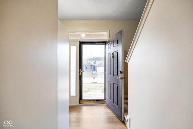 entryway featuring stairway, a healthy amount of sunlight, and light wood-style floors