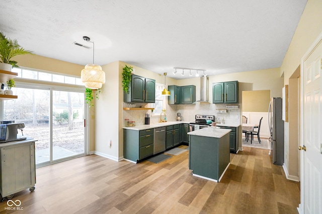 kitchen featuring a center island, tasteful backsplash, stainless steel appliances, and green cabinetry