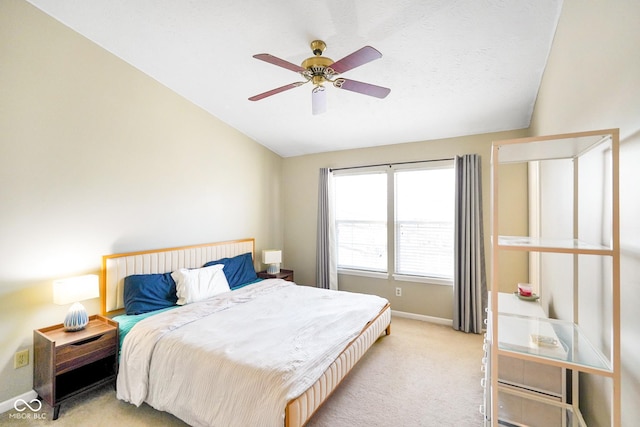 bedroom featuring baseboards, light colored carpet, ceiling fan, and vaulted ceiling