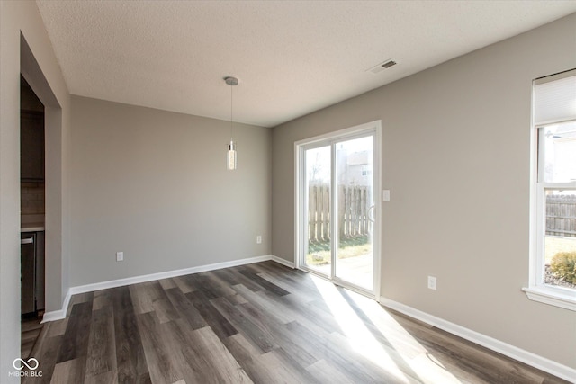 interior space with dark wood-style floors, visible vents, and baseboards