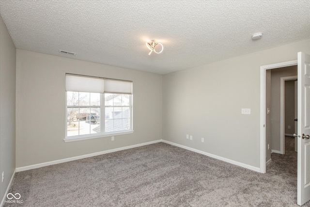 spare room with baseboards, visible vents, carpet floors, and a textured ceiling