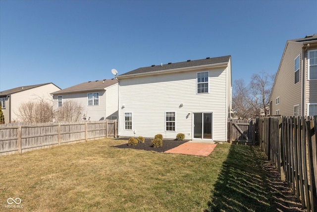 rear view of house featuring a fenced backyard, a patio, and a yard