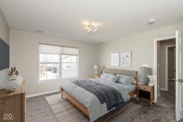 bedroom featuring visible vents, carpet floors, a textured ceiling, and baseboards