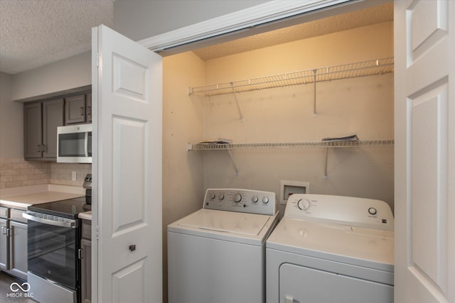 laundry room with washer and clothes dryer, laundry area, and a textured ceiling