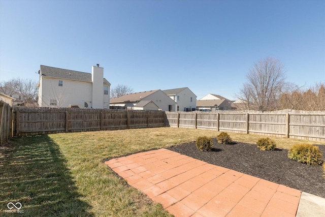 view of yard featuring a residential view, a patio, and a fenced backyard